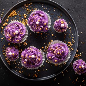 Sweet cupcakes with violet cream ready to eat. Magnificent purple dessert with golden sprinkles.